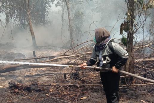 A woman is fighting forest fire
