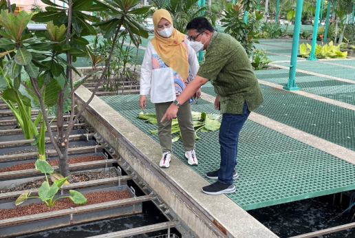 A woman and a man standing on a wastewater treatment plant in an eco-industrial park.
