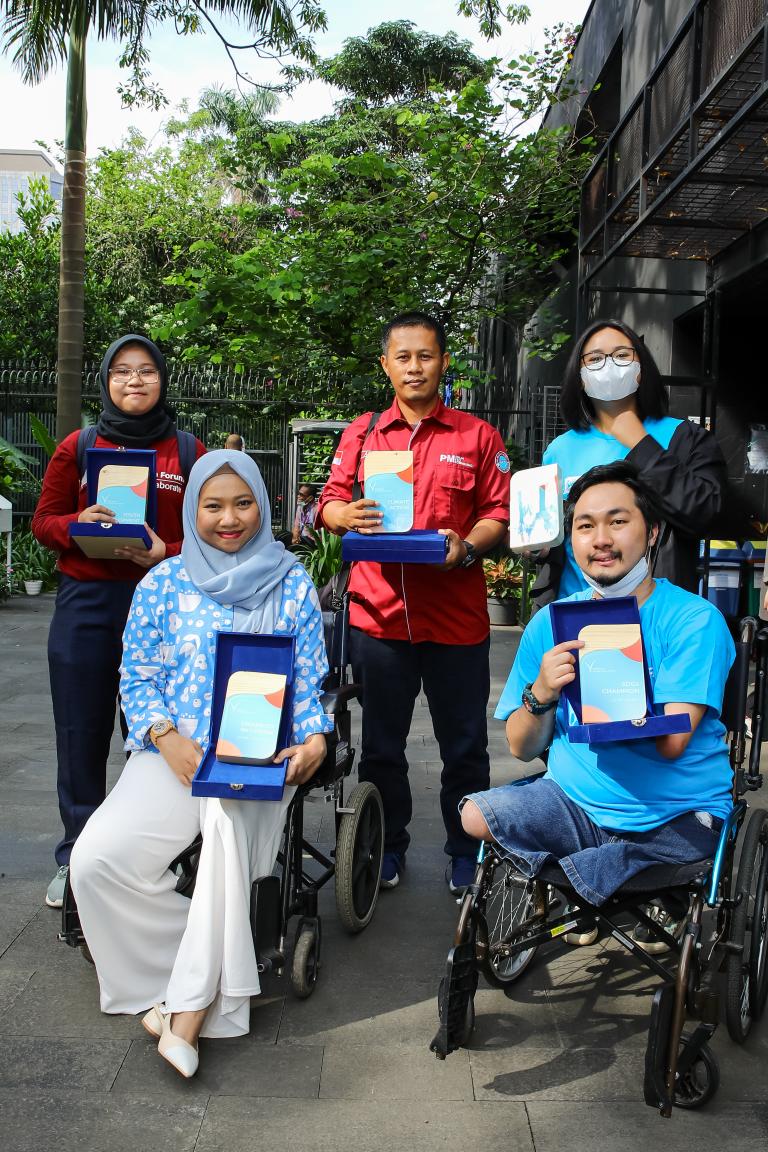 5 UN Volunteers awards winners are posing with placard 